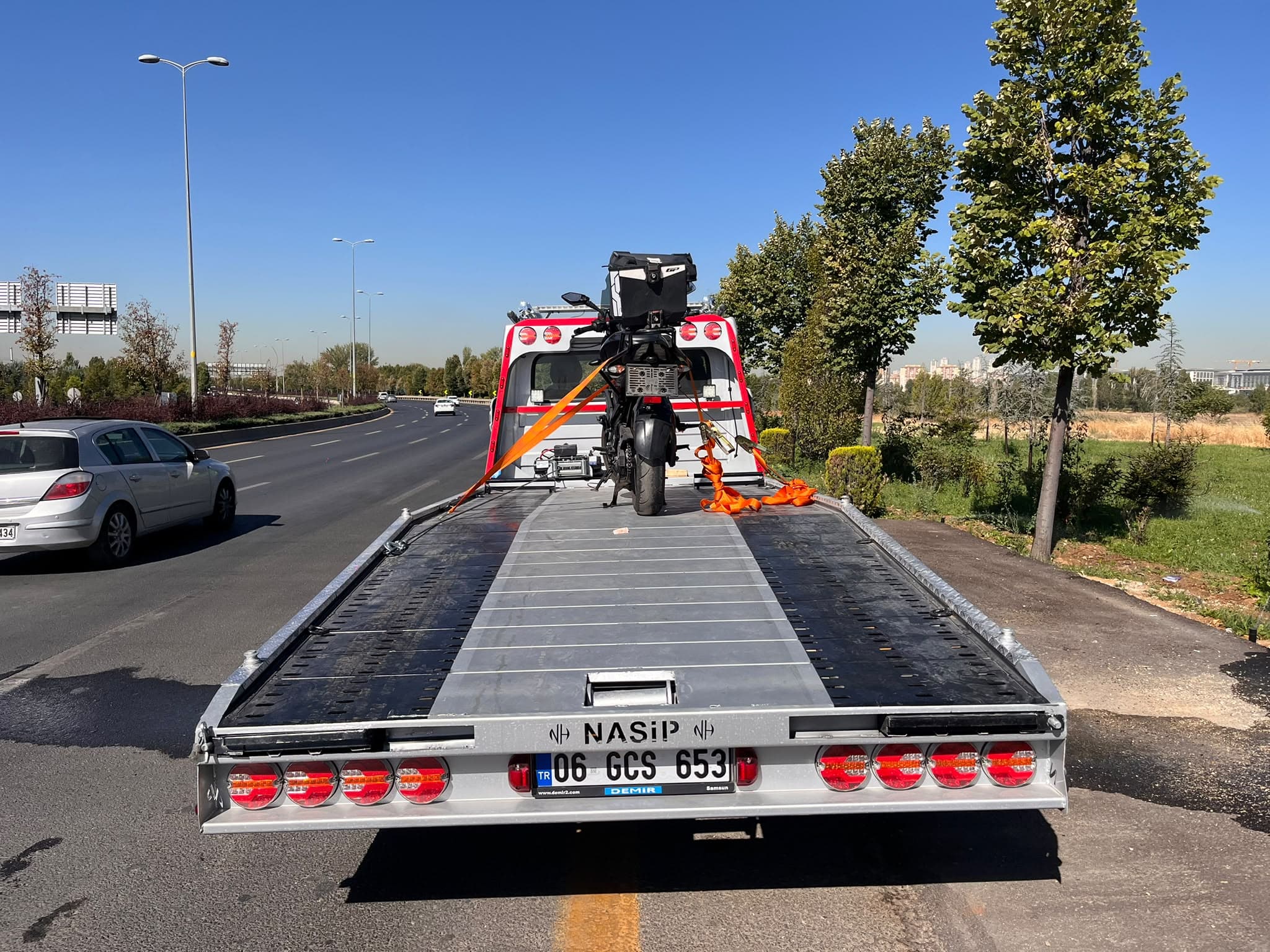 Prime Oto Kurtarma çekicisi bir motosikleti platformuna yükleyip şehir içinde taşıyor